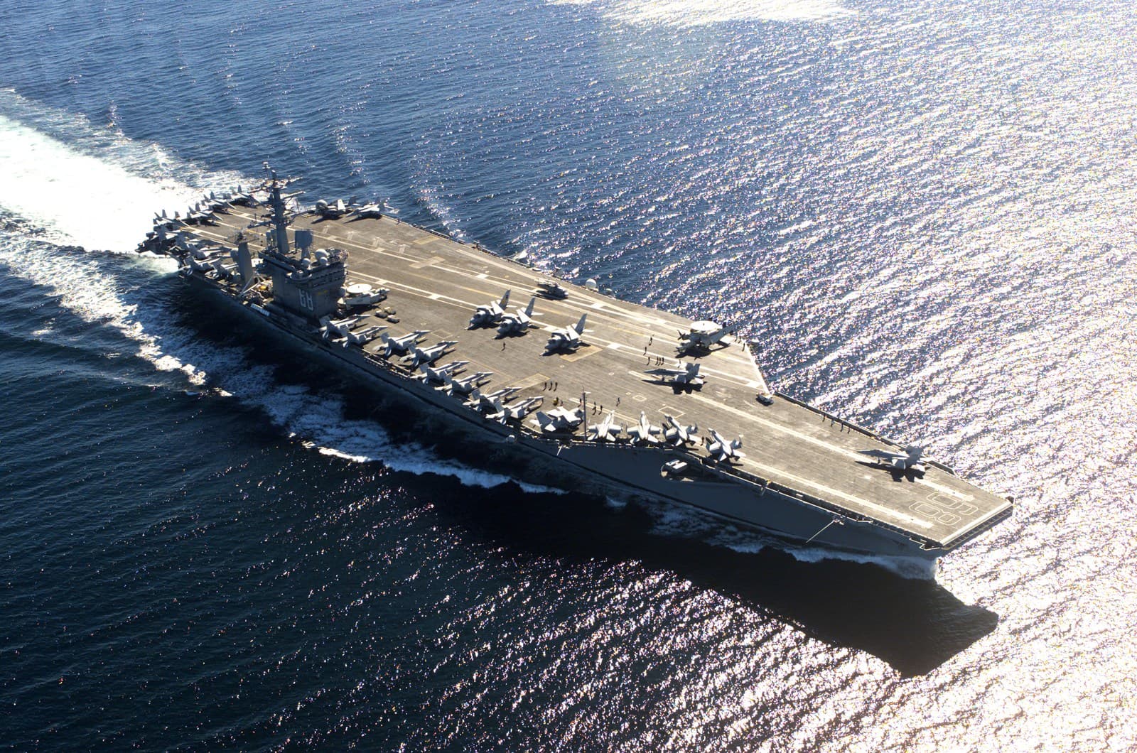 Real aerial photograph of USS Nimitz (CVN-68), showing the full Nimitz-class aircraft carrier and its flight deck.