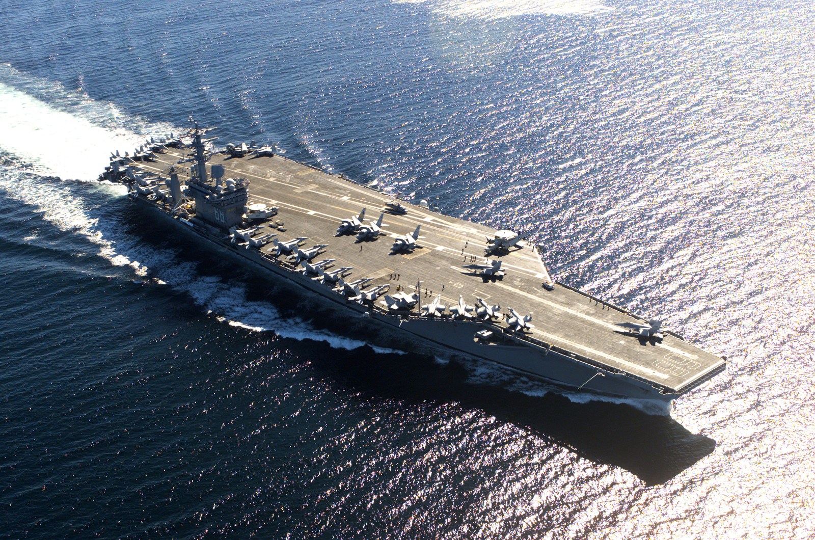 Real aerial photograph of USS Nimitz (CVN-68), showing the full Nimitz-class aircraft carrier and its flight deck.